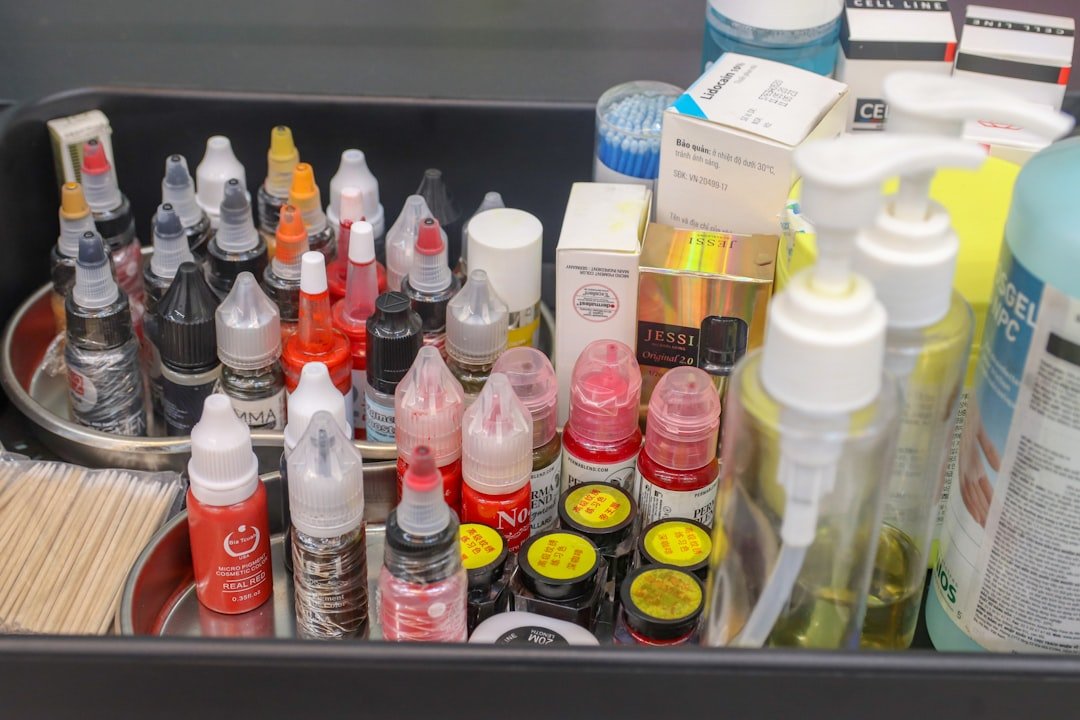 Variety of colorful biodegradable tattoo ink bottles arranged on tattoo studio workstation